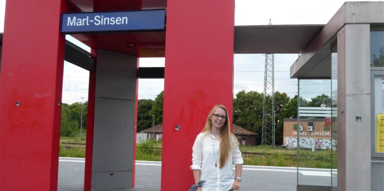 Eine junge Frau aus Marl steht auf dem Bahnsteig des Bahnhofs Marl-Sinsen.