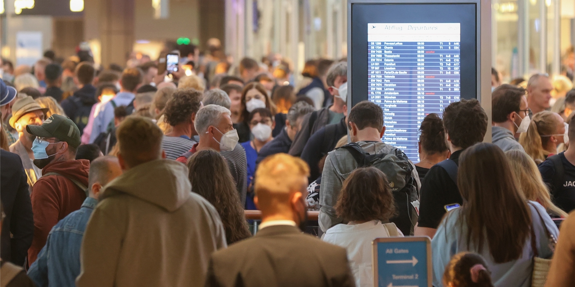 Zahlreiche Reisende warten am Morgen in Schlangen vor der Sicherheitskontrolle am Hamburger Flughafen.