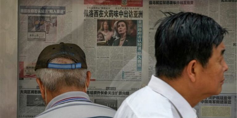 Zwei Männer stehen in Taipeh vor einem Schaukasten mit Zeitungen und lesen