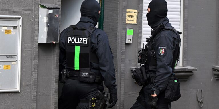 Polizisten untersuchen Wohnungen bei einer Drogenrazzia.