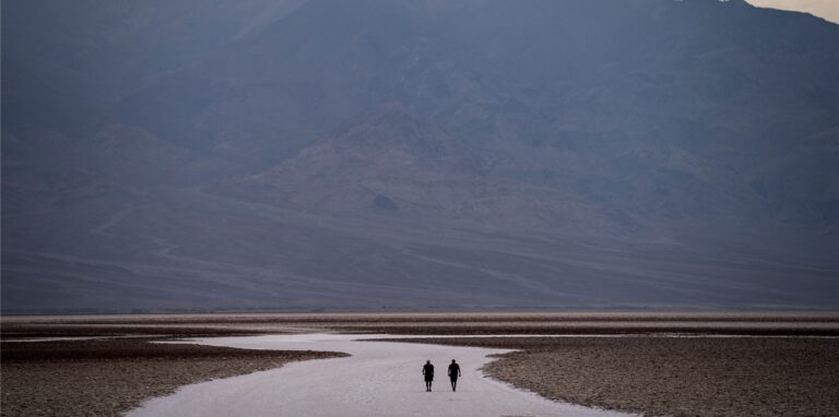 Menschen spazieren auf Salzebenen im Badwater Basin.