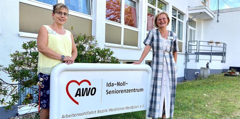 Leiterin Ulrike Mann-Volland und Sozialarbeiterin Dors Maj vor dem Eingangsschild in das Ida-Noll-Seniorenzentrum