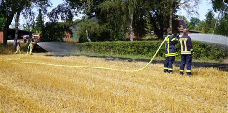 Feuerwehrkräfte der Hauptwache löschen letzte Glutnester auf einem Feld in Catsrop-Rauxel.