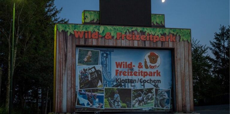 Ein Schild in der Nähe des Eingangs weist auf Ein- und Ausgang des Wild-und Freizeitparks hin.