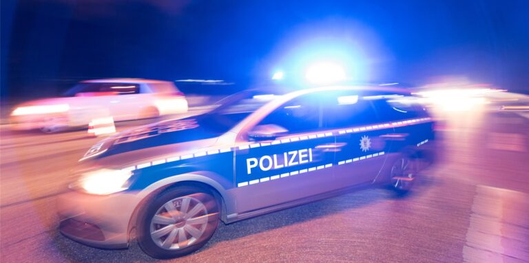 Ein Polizeifahrzeug steht mit Blaulicht auf der Straße.
