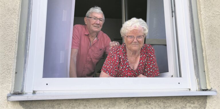 Johann Grensemann (82) steht mit seiner Bekannten Elfriede Stoermann (85) am Fenster und beobachtet eine Kunstaktion am Bunker hinter dem Haus.