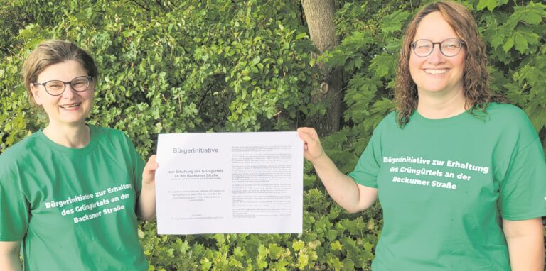 Die Sprecherinnen der „Bürgerinitiative zur Erhaltung des Grüngürtels an der Backumer Straße“, Claudia Bischoff (l.) und Sabine Kiepert, mit einem Informationsblatt.