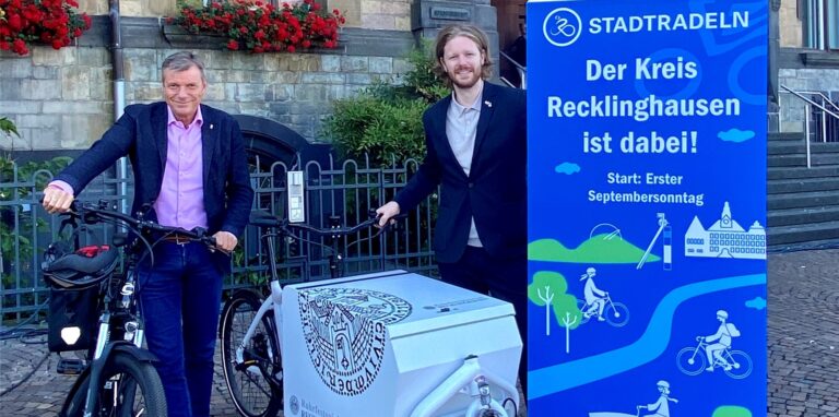Bürgermeister Christoph Tesche (l.) und Nahmobilitätskoordinator David Herz stehen mit Fahrrädern vor dem Rathaus in Recklinghausen