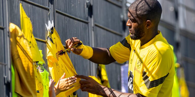 Anthony Modeste unterschreibt ein Trikot.