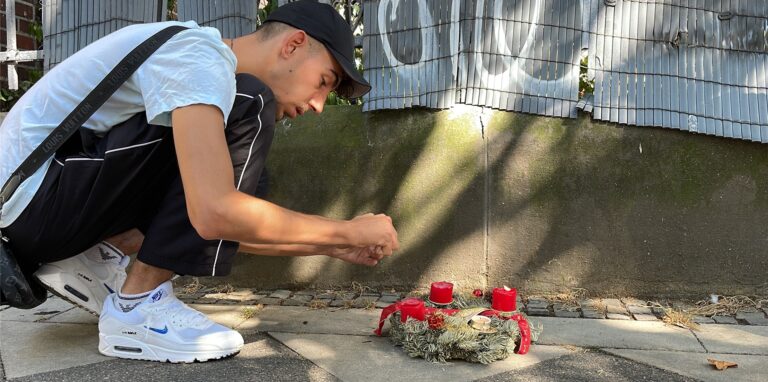 Serden, 22, aus dem Viertel, legt einen Kranz nieder.