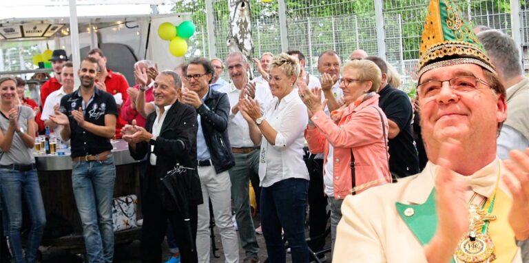 Hinten fröhliche Menschen, vorne Reinhard Lackmann