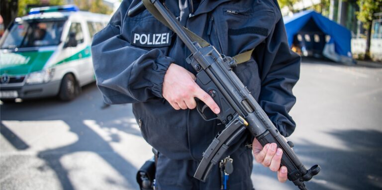 Ein Polizist steht mit einer MP-5 des Herstellers Heckler & Koch auf der Straße