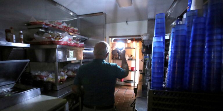 Restaurantmanager Rich Fuxjager hält eine batteriebetriebene Lampe in der Küche von «Marias Restaurant» nach einem Stromausfall.