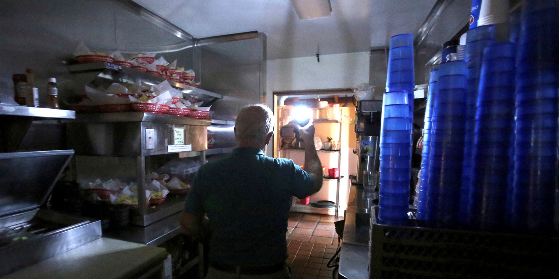 Restaurantmanager Rich Fuxjager hält eine batteriebetriebene Lampe in der Küche von «Marias Restaurant» nach einem Stromausfall.