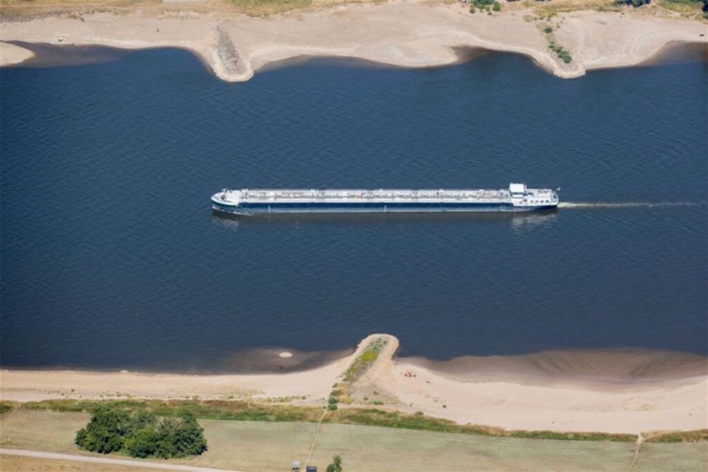 Ein Schiff mit wenig Ladung fährt bei Köln bei niedrigem Wasserstand auf dem Rhein.