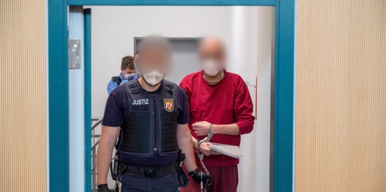 Ein Justizbediensteter begleitet den 52-jährigen Angeklagten (r) zum Prozess um die tödliche Amokfahrt in Trier in den Gerichtssaal des Landgerichts.