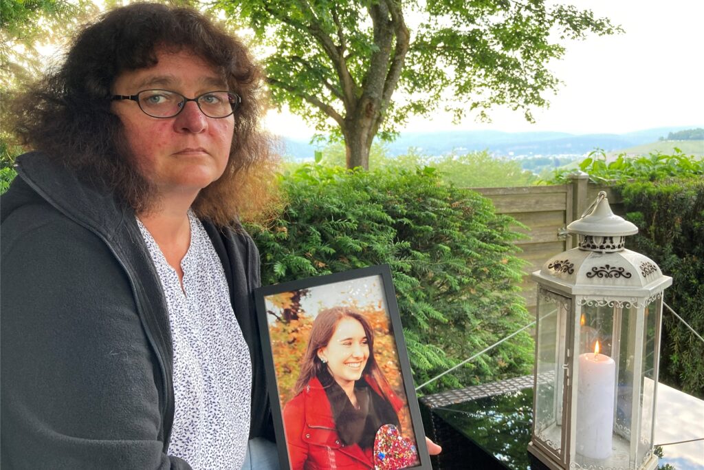 Petra Lieser sitzt mit einem Foto ihre Tochter in ihrem Garten in Trier. Die Tochter Katja Lieser war am 1. Dezember 2020 bei einer Amokfahrt in Trier getötet worden