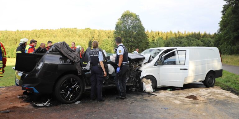 Rettungskräfte stehen an zerstörten Fahrzeugen. Bei einem schweren Verkehrsunfall auf der B28 bei Römerstein (Landkreis Reutlingen) ist nach Polizeiangaben mindestens ein Mensch ums Leben gekommen.