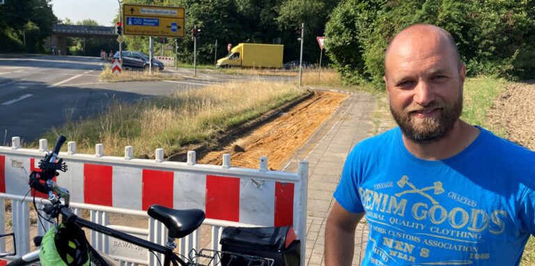 Benjamin Stracke steht am nördlichen Ende der Baustelle an der Zufahrt zum Autobahnzubringer. Der asphaltierte Radweg (im Hintergrund) ist bereits abgetragen.