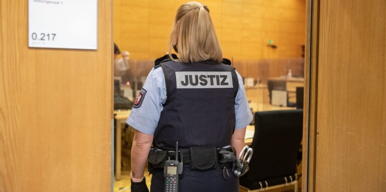 Eine Justizbeamtin steht in einem Saal vom Landgericht Bielefeld.