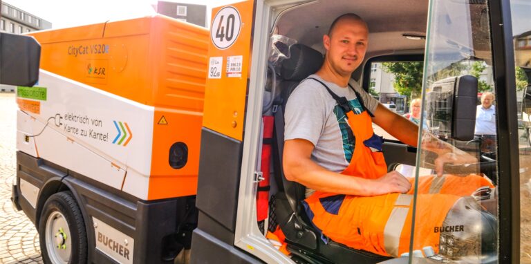 Dennis Köhler, Fahrer bei den Kommunalen Servicebetrieben Recklinghausen, sitzt im Führerhaus einer elektrischen Kehrmaschine.