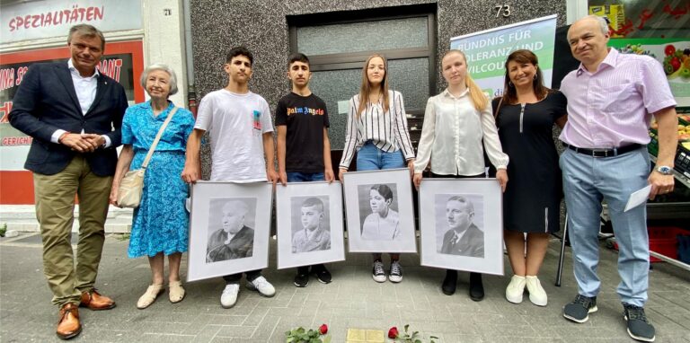 Eine Gruppe von Menschen steht vor neuen Stolpersteinen auf dem Bürgersteig an der Bochumer Straße in Recklinghausen.