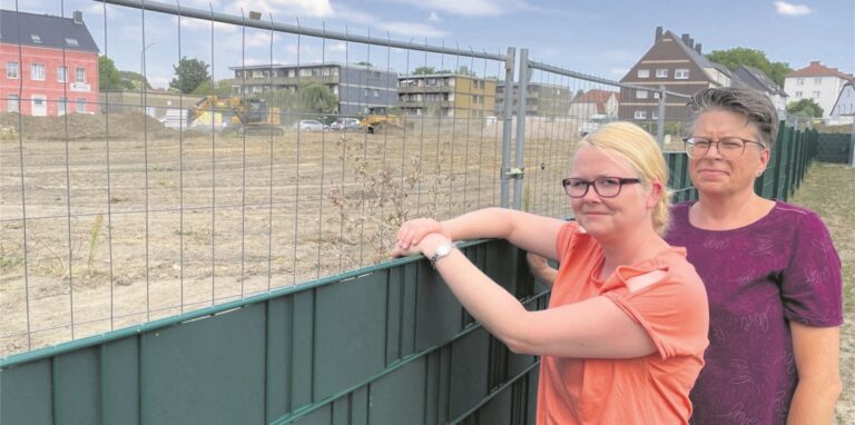 Nur ein grüner Kunststoffzaun trennt das Areal der Kindertagesstätte Sonnenblume von der Baustelle an der Ecke Feldstraße/Westerholter Straße. Die Kita-Leiterinnen Darinka Klebeck (36, links) und Stephanie Edelmann (52) schauen auf die staubige Mondlandschaft jenseits der Umzäunung.