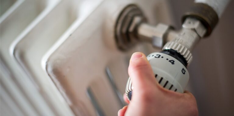 Eine Frau dreht am 20.10.2014 in Hannover (Niedersachsen) am Thermostat einer Heizung.