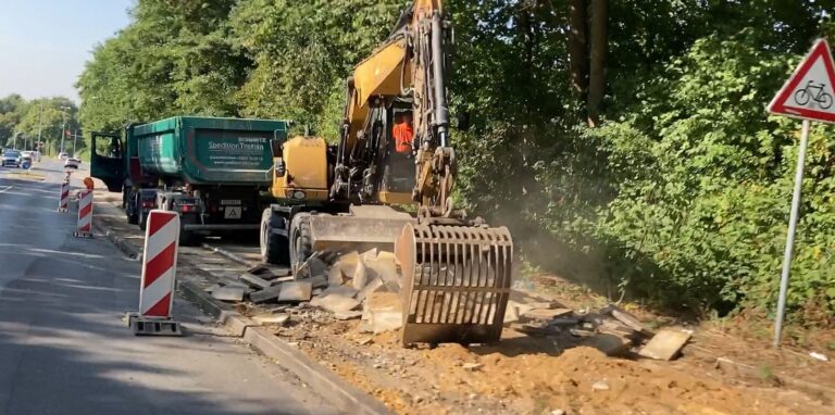 Der asphaltierte Radweg neben der Straße „Über den Knöchel“ ist bereits abgefräst, hier reißt ein Bagger die Platten des Gehwegs heraus.