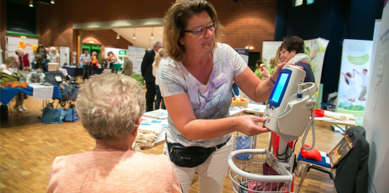 Eine Frau führt medizinische Geräte auf der Messe Gesund und munter in Recklinghausen vor