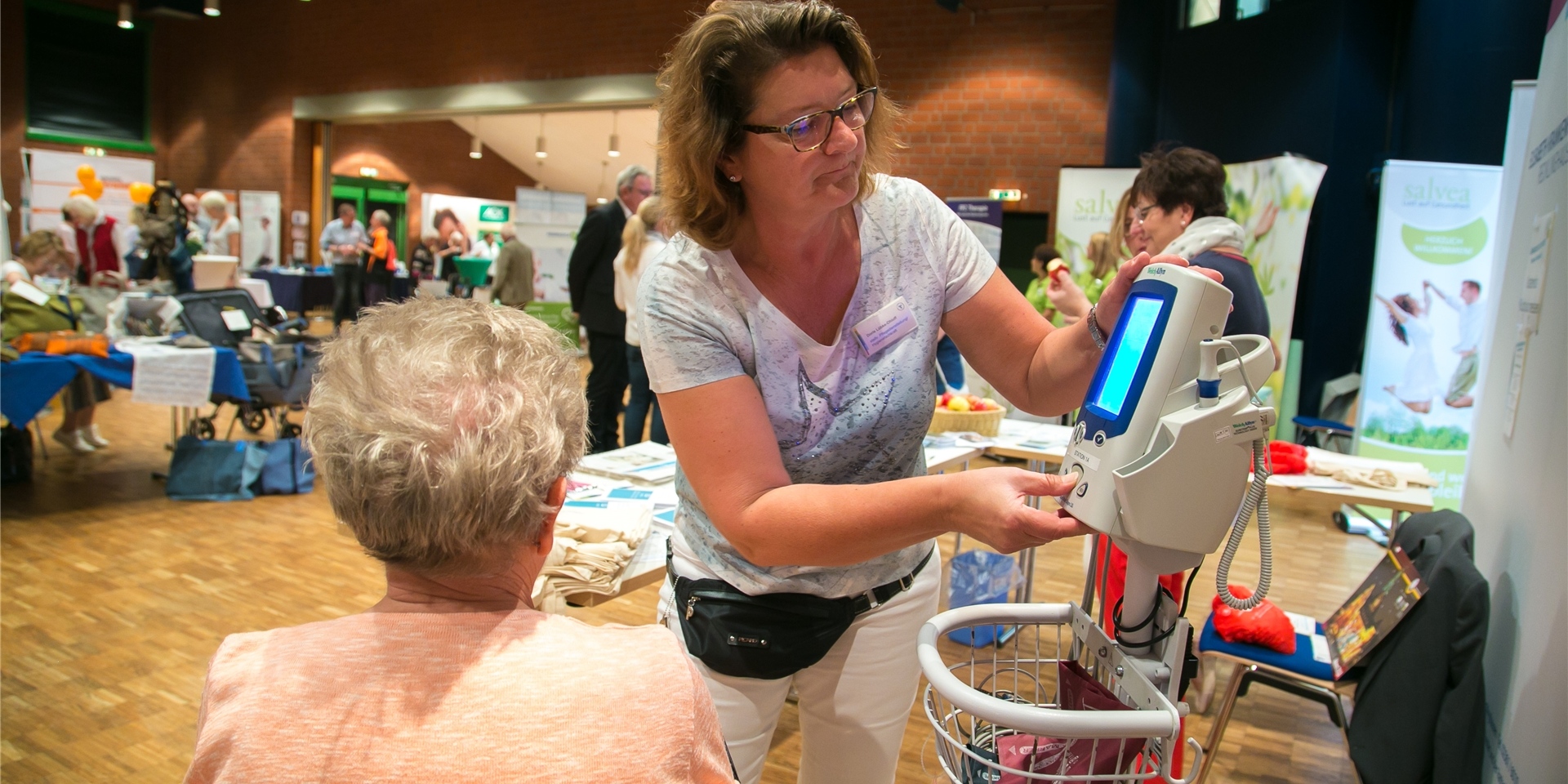 Eine Frau führt medizinische Geräte auf der Messe Gesund und munter in Recklinghausen vor