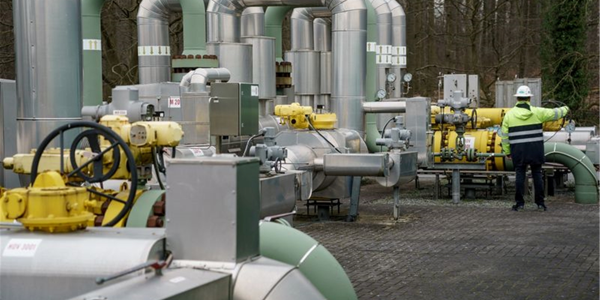 Ein Mann steht an einer Gasanlage.