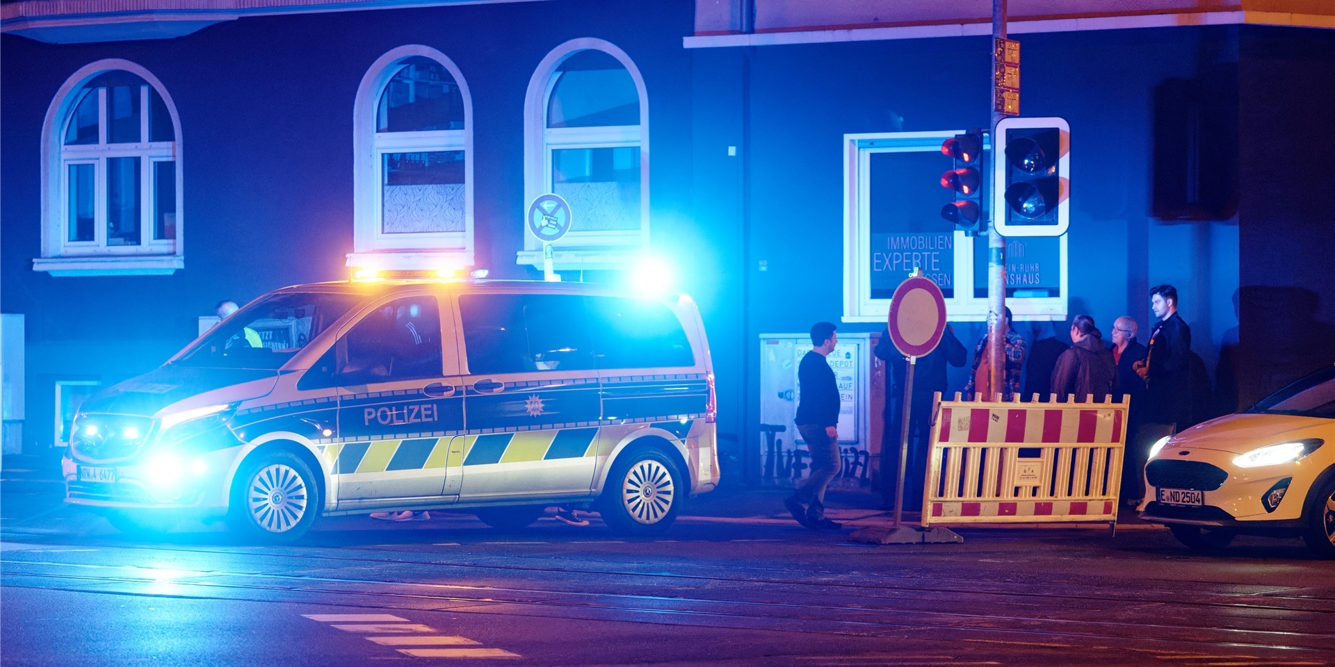 Ein Polizeiwagen steht mit Blaulicht an einer Straße (Symbolbild).