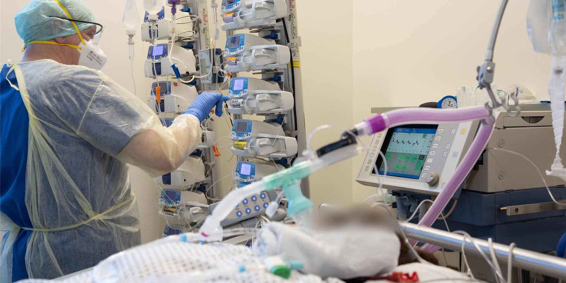 Ein Krankenpfleger versorgt einen schwer an Corona erkrankten Patienten auf einer Intensivstation