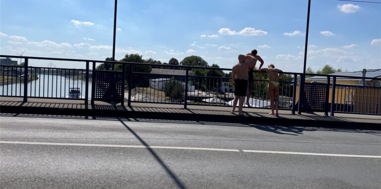 Brückenspringer machen sich am Rhein-Herne-Kanal bereit für die Abkühlung im Kanal.