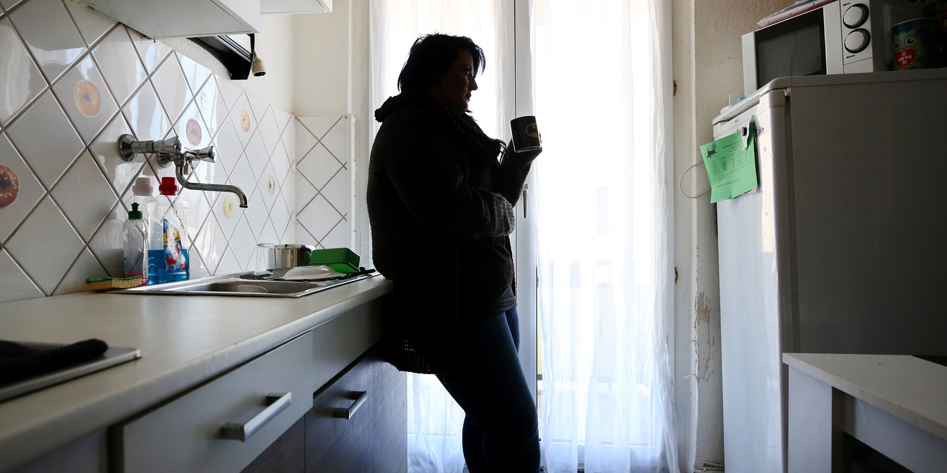 Eine Mutter von drei kleinen Kindern steht in Gelsenkirchen (Nordrhein-Westfalen) in ihrer Küche