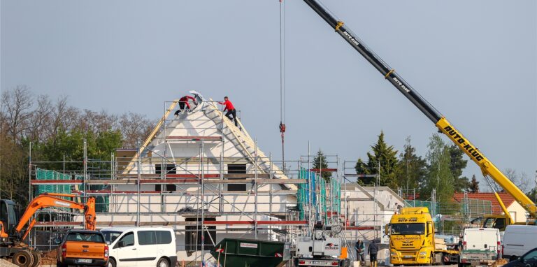 Handwerker bei der Arbeit am Rohbau eines Einfamilienhauses.