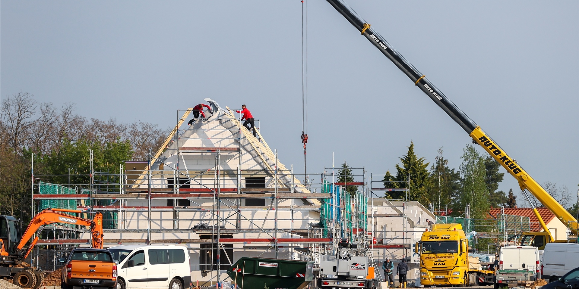 Handwerker bei der Arbeit am Rohbau eines Einfamilienhauses.