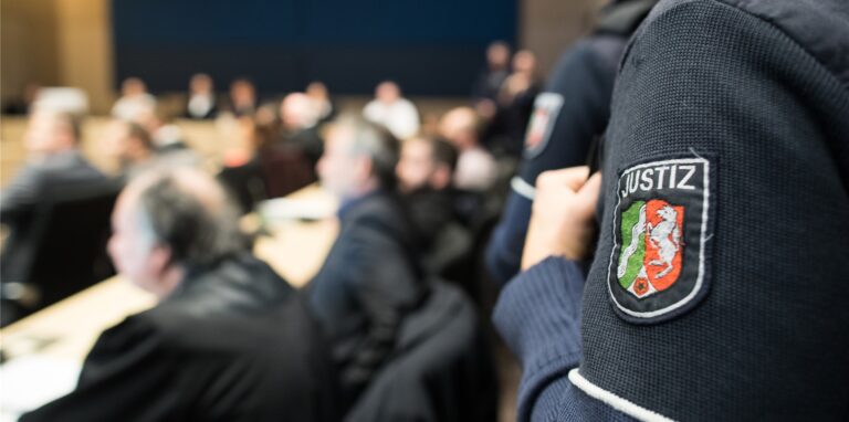 Bochum: Angeklagte sitzen im Landgericht im Gerichtssaal neben ihren Anwälten.