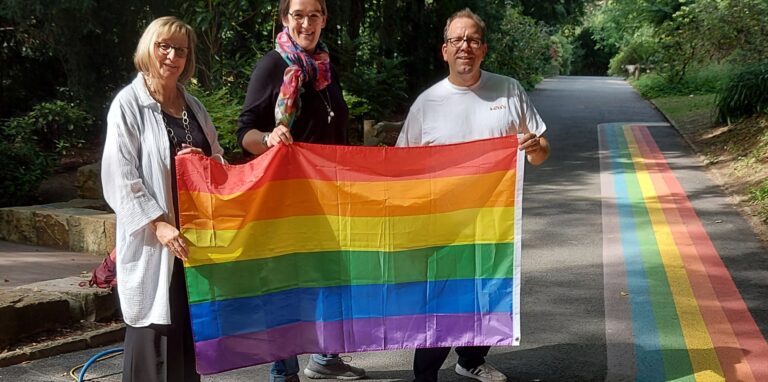 Annette Kulozik (Geschäftsbereichsleiterin Parkanlagen), Christine Brämer (Koordinierungsstelle für LSBTIQ der Stadt Dortmund) und Dr. Patrick Knopf (Direktor Botanischer Garten Rombergpark) weihen den neuen Regenbogen-Weg ein.