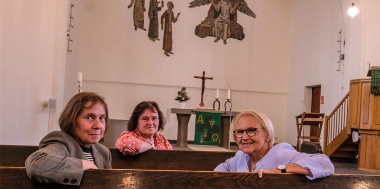 Gabi Krüger, Andrea Olschewski und Hannelore Klippel sitzen in den Bänken der Reformationskirche in Recklinghausen vor dem Altarraum.