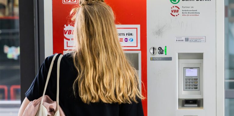 Eine Frau kauft am Berliner Bahnhof Ostkreuz am Automaten eine Fahrkarte.