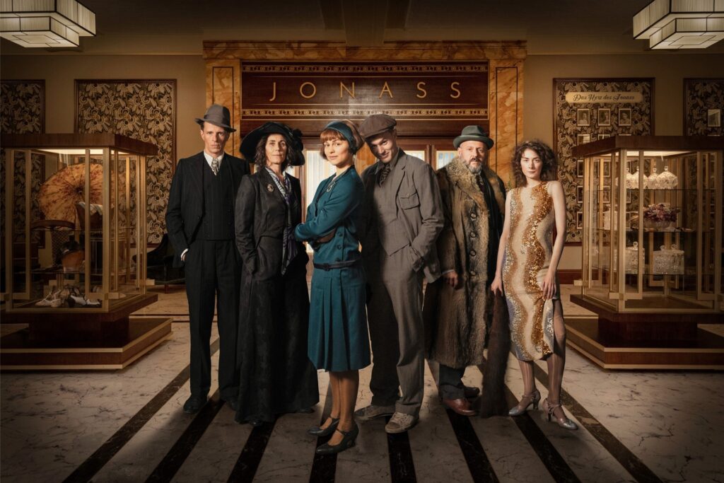Arthur Grünberg (Alexander Scheer, l-r), Alice Grünberg (Nina Kunzendorf), Vicky Maler (Naemi Feitisch), Harry Grünberg (Ludwig Simon), Carl Goldmann (Samuel Finzi), Elsie Schön (Amy Benkenstein) stehen vor dem Kaufhaus Arthur Grünberg (Alexander Scheer, l-r), Alice Grünberg (Nina Kunzendorf), Vicky Maler (Naemi Feitisch), Harry Grünberg (Ludwig Simon), Carl Goldmann (Samuel Finzi), Elsie Schön (Amy Benkenstein) stehen vor dem Kaufhaus