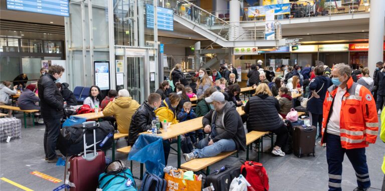 Geflüchtete aus der Ukraine sitzen nach der Ankunft eines Flugzeuges aus Chisinau/Moldau im Flughafen Erfurt-Weimar und werden von Helfern betreut.