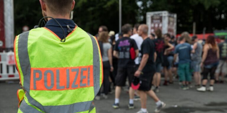 Ein Polizist steht am Rande eines Musikfestivals