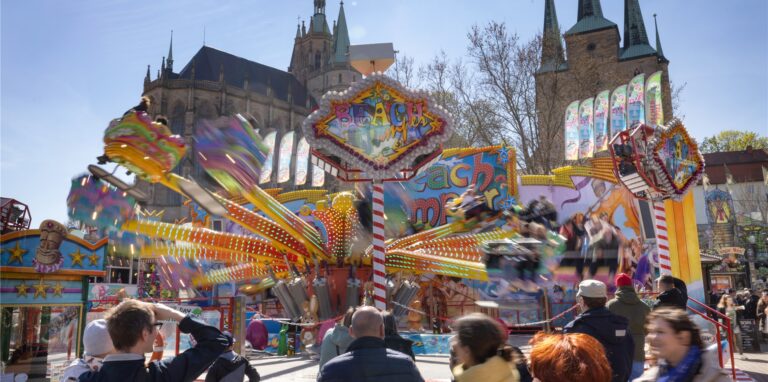 Menschen vergnügen sich am Ostersamstag auf einem Karussell beim Altstadtfrühling auf dem Domplatz. 