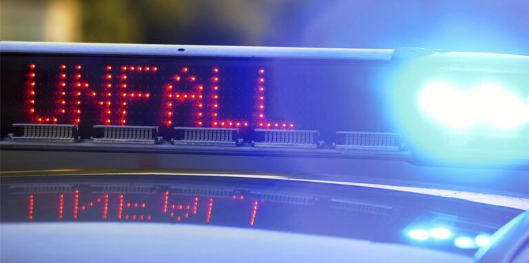 Auf einem Polizeifahrzeug warnt eine Leuchtschrift vor einer Unfallstelle (Symbolbild).