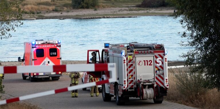 Fahrzeuge der Feuerwehr stehen am Rhein.
