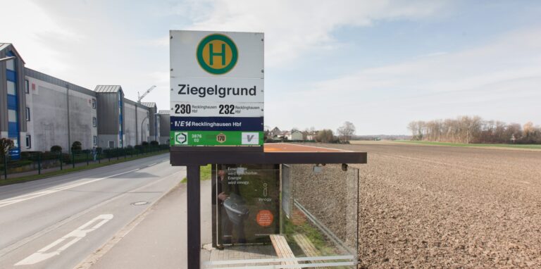 Bushaltestelle neben der Dortmunder Straße, rechts ist ein Feld zu sehen.