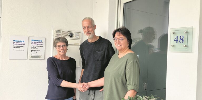 Maria Aust-Andreo und Nachfolgerin Regina Pawlowski geben einander vor der Jugendhilfestation der Diakonie in Waltrop die Hand. Dahinter steht Gruppenleiter Mike Felling.